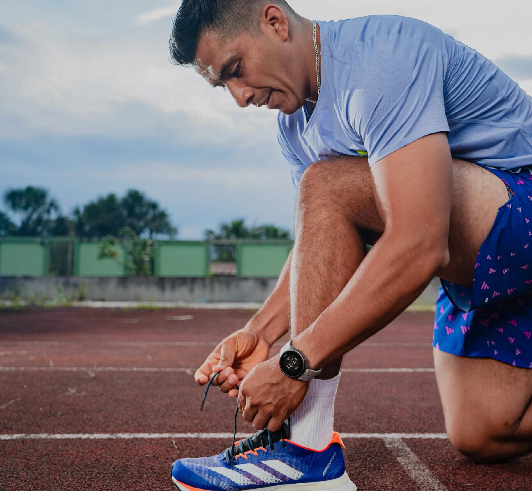 Mann bindet sich die Schuhe in Laufklamotten
